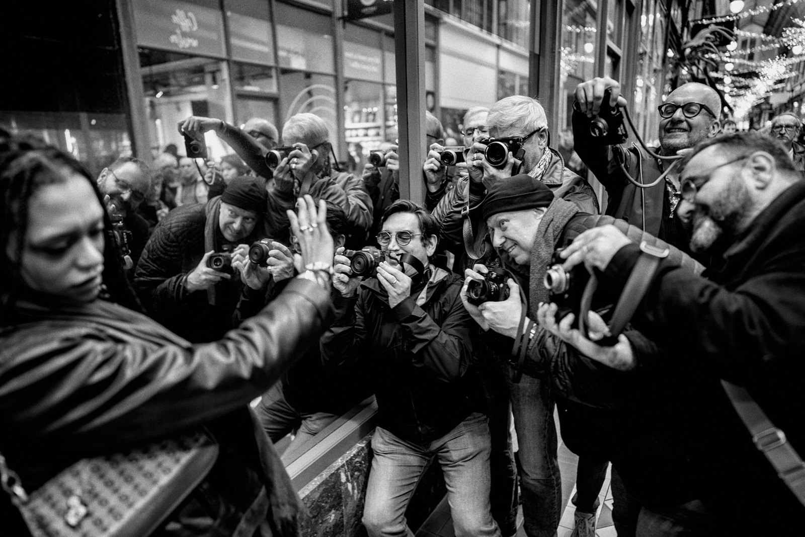 Les participants d’une MASTERCLASS photographient un modèle dans un passage couvert parisien