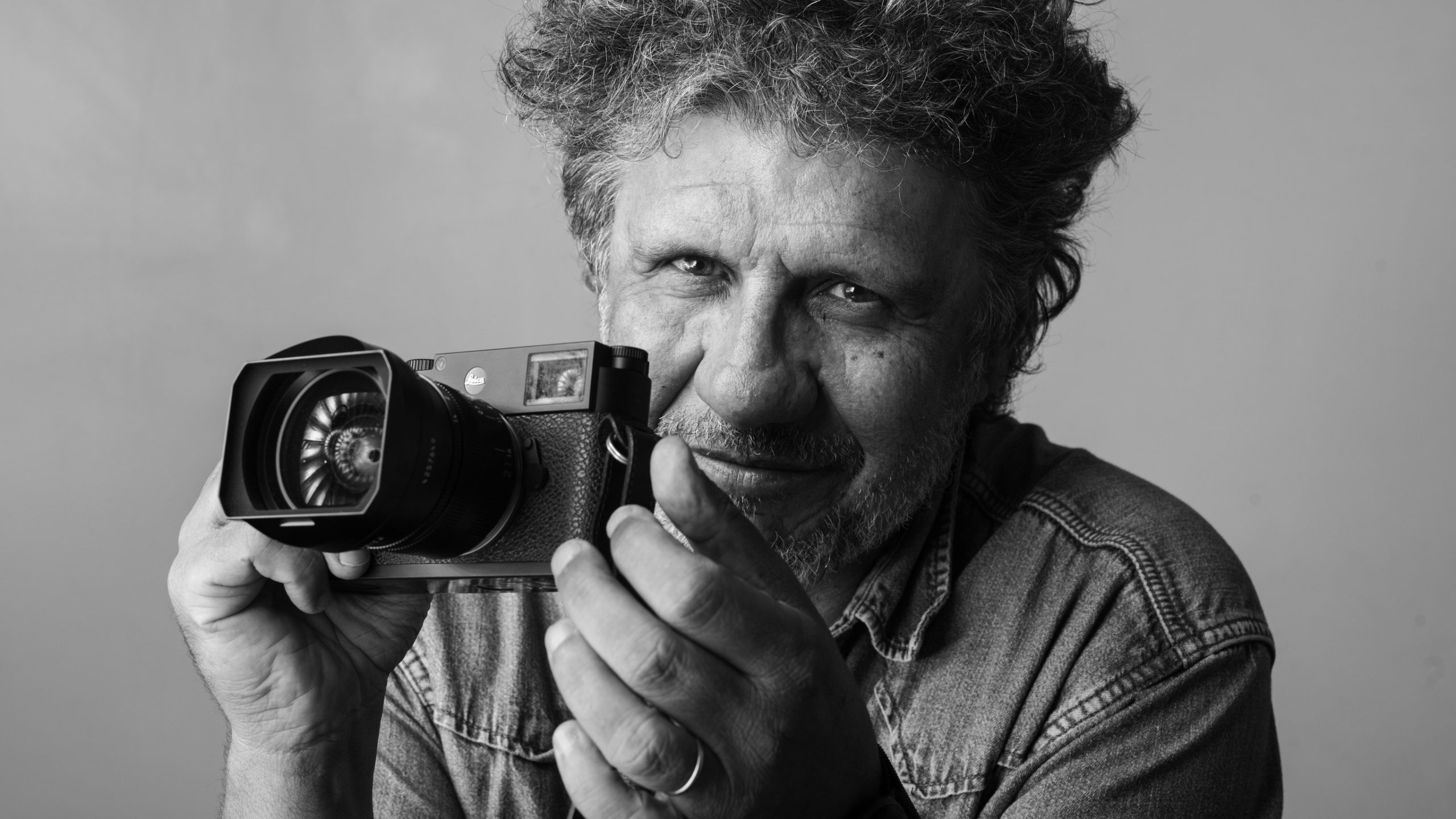 Portrait noir et blanc de David Ken, appareil photo en main