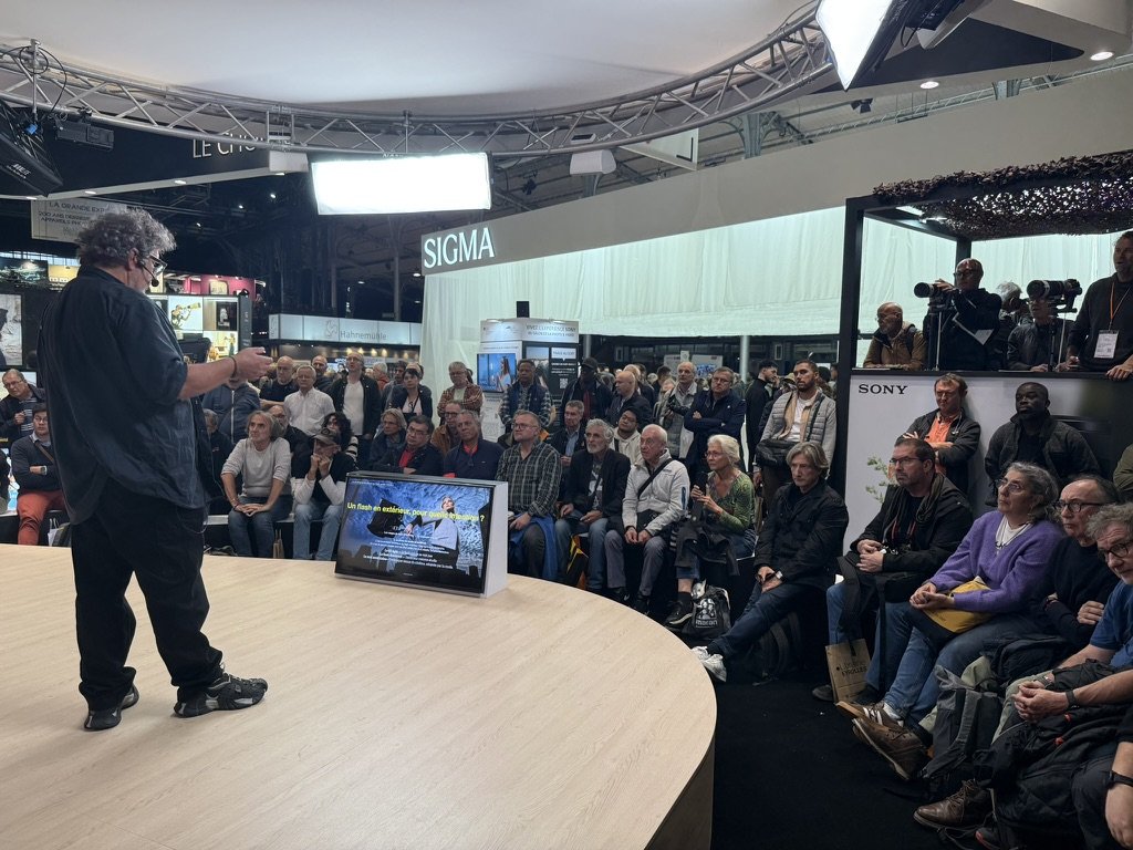 David Ken en conférence sur l’histoire du flash devant une foule nombreuse, scène Sony, Salon Photo & Vidéo 2026